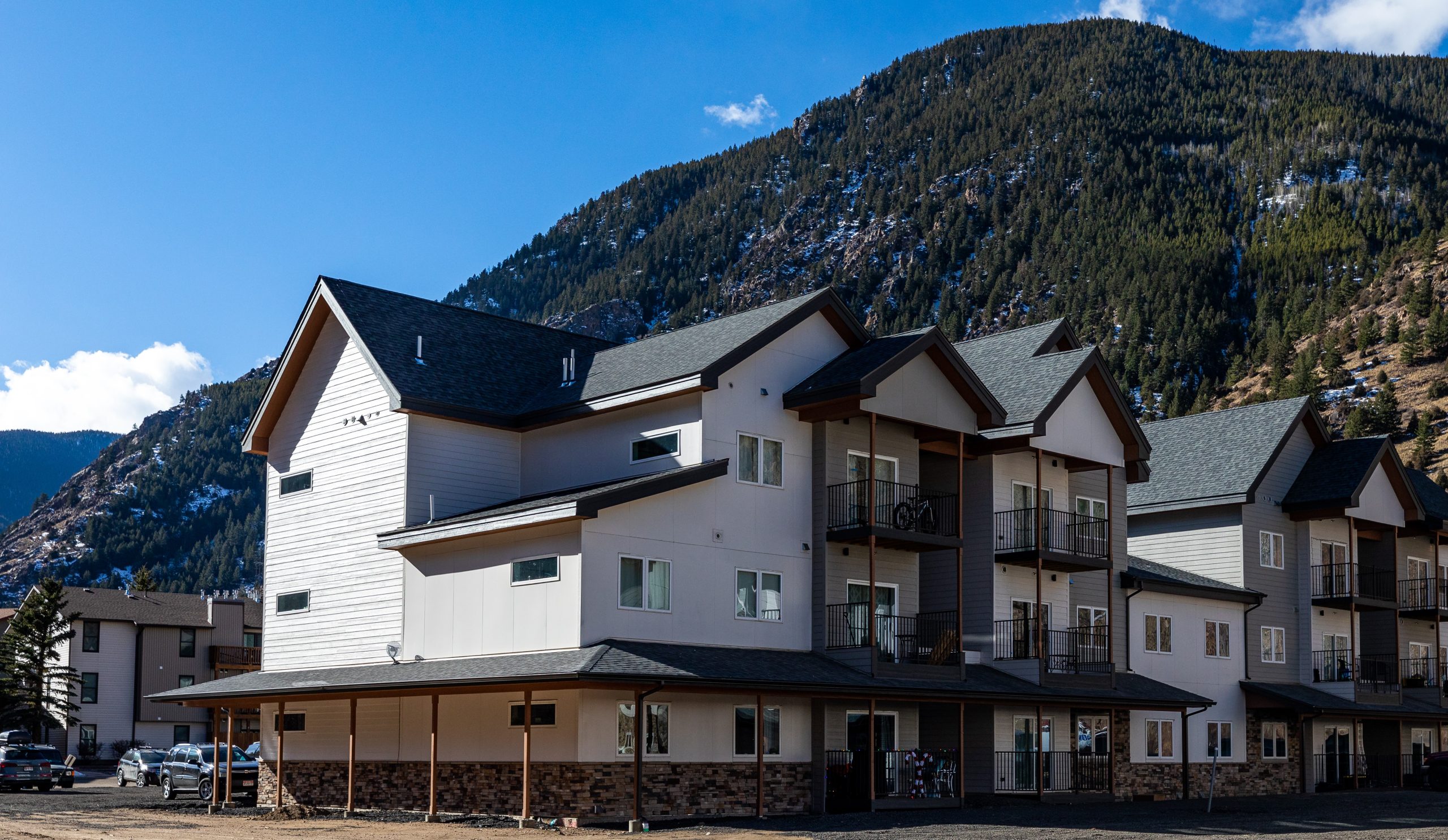 the building is white and has a mountain view at The Bighorn Crossing