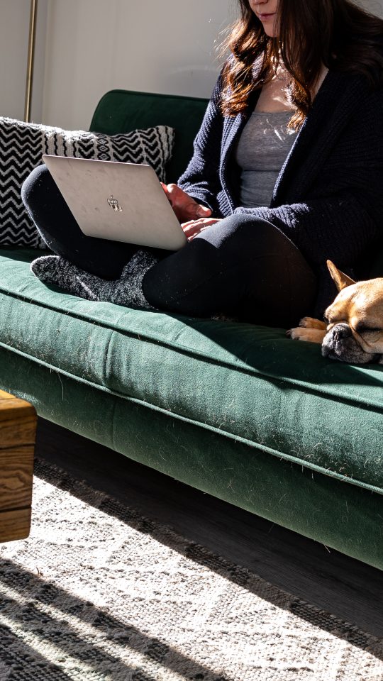 a woman sitting on a couch with a dog on her lap at The Bighorn Crossing