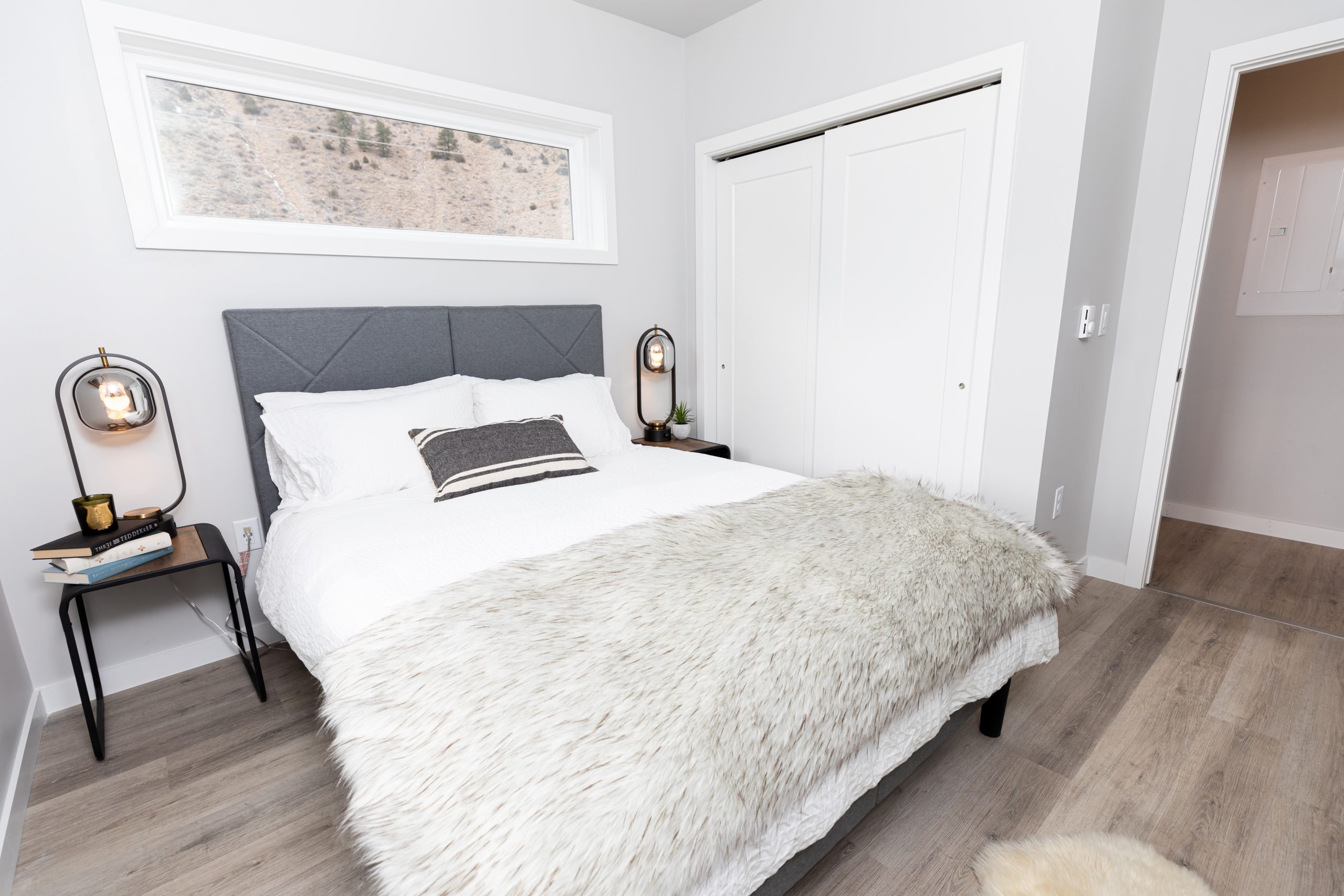 a bedroom with a white bed and a gray rug at The Bighorn Crossing