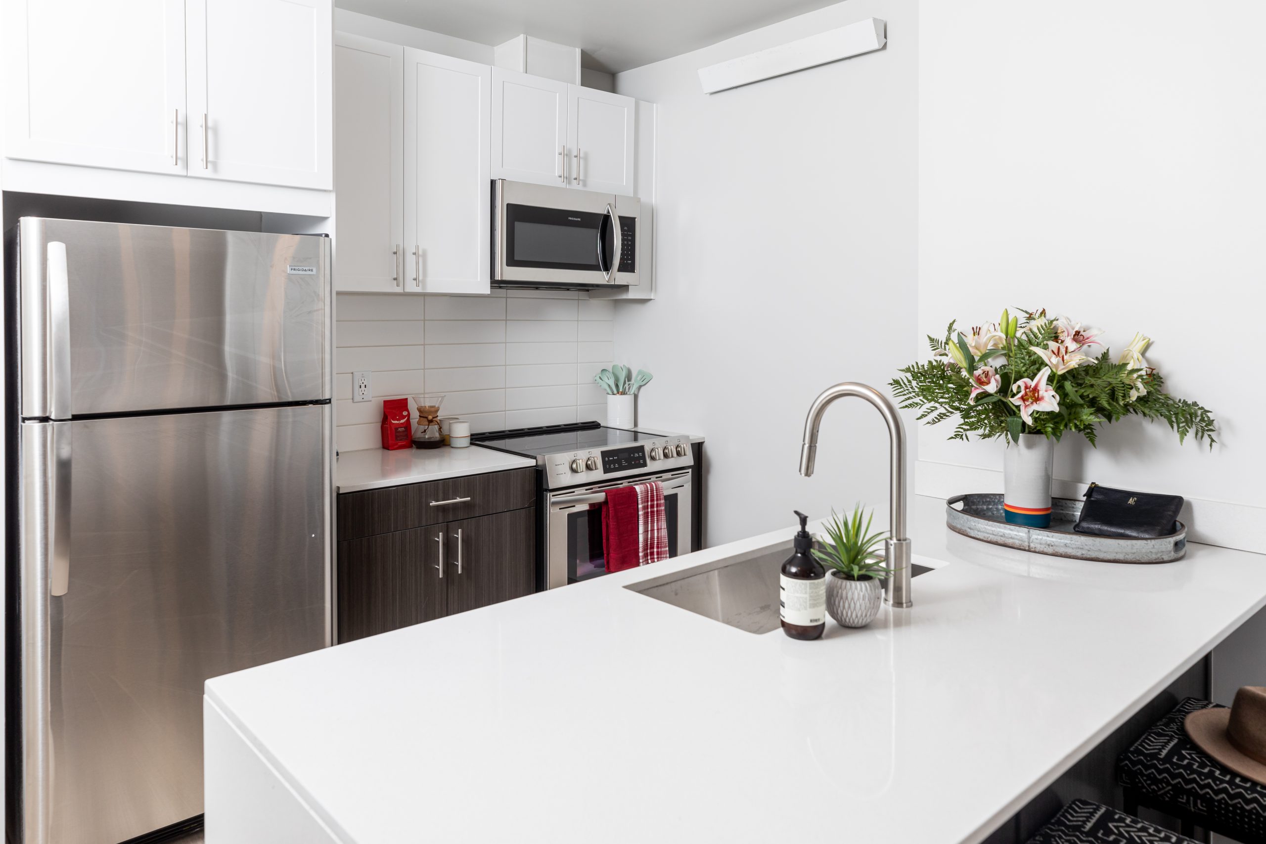 a white kitchen with stainless steel appliances and a sink at The Bighorn Crossing