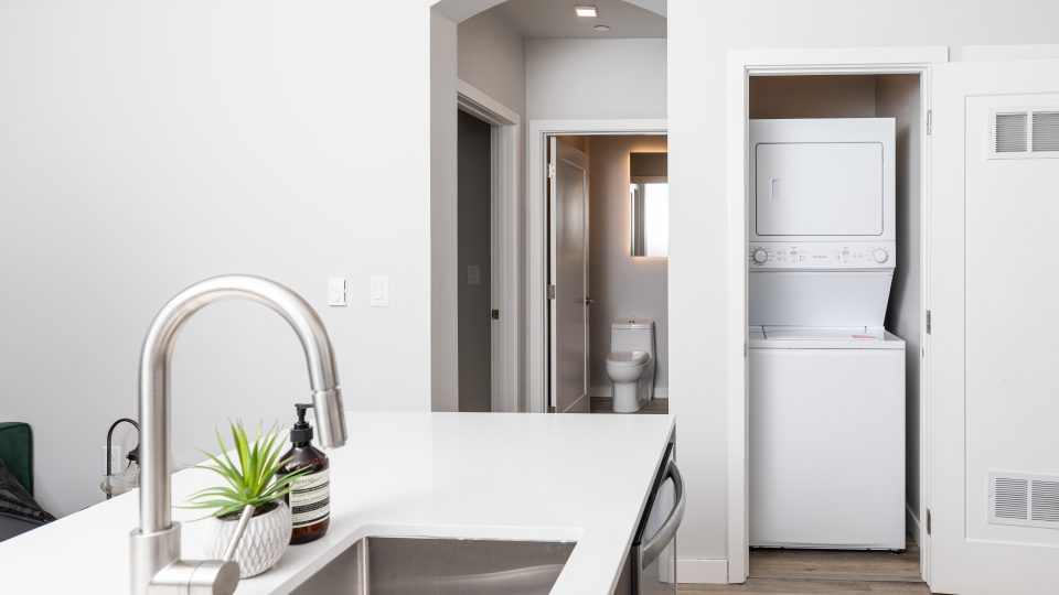 a kitchen with a sink and a washer and dryer at The Bighorn Crossing